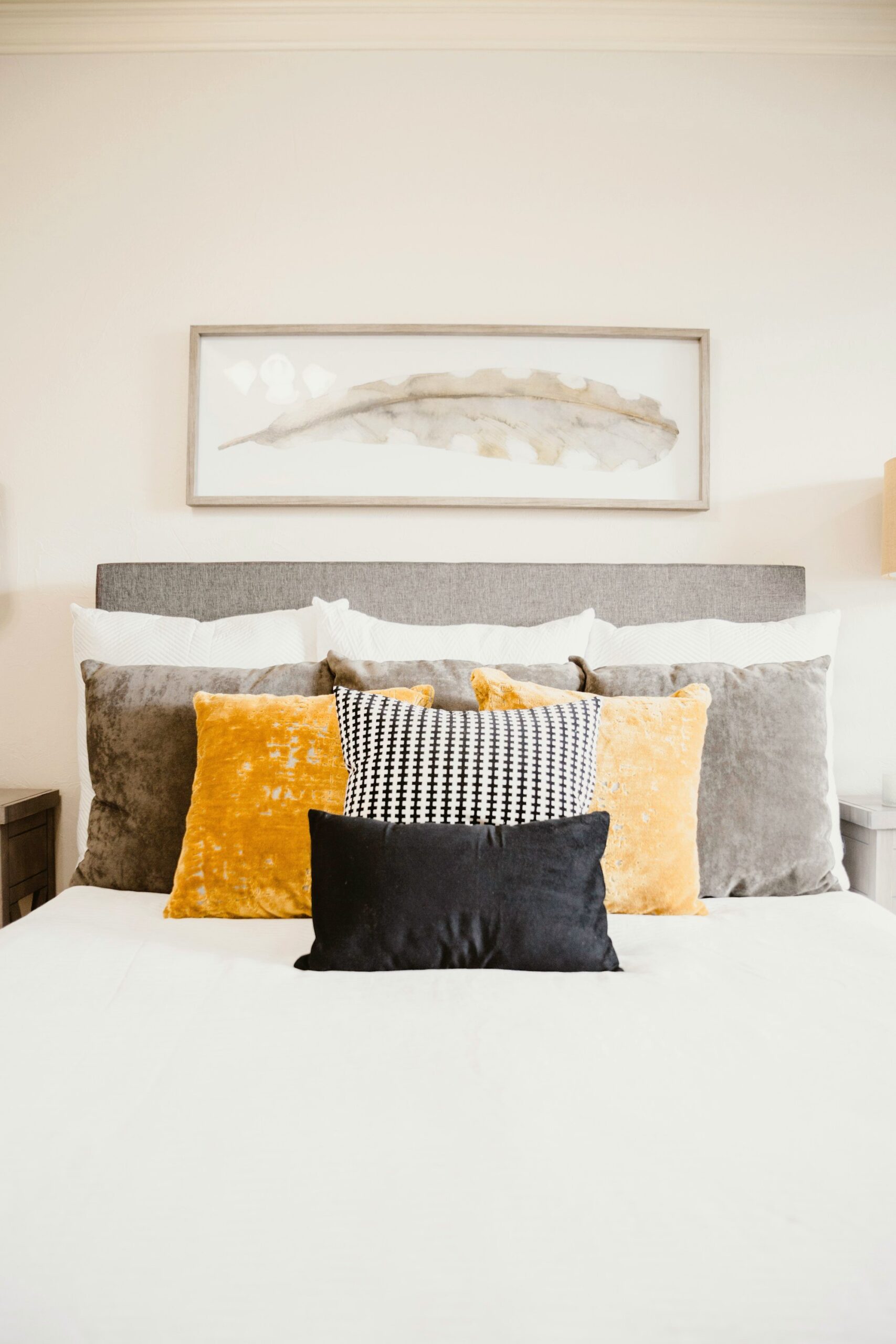 Neutral bed styled with mixed-texture throw pillows