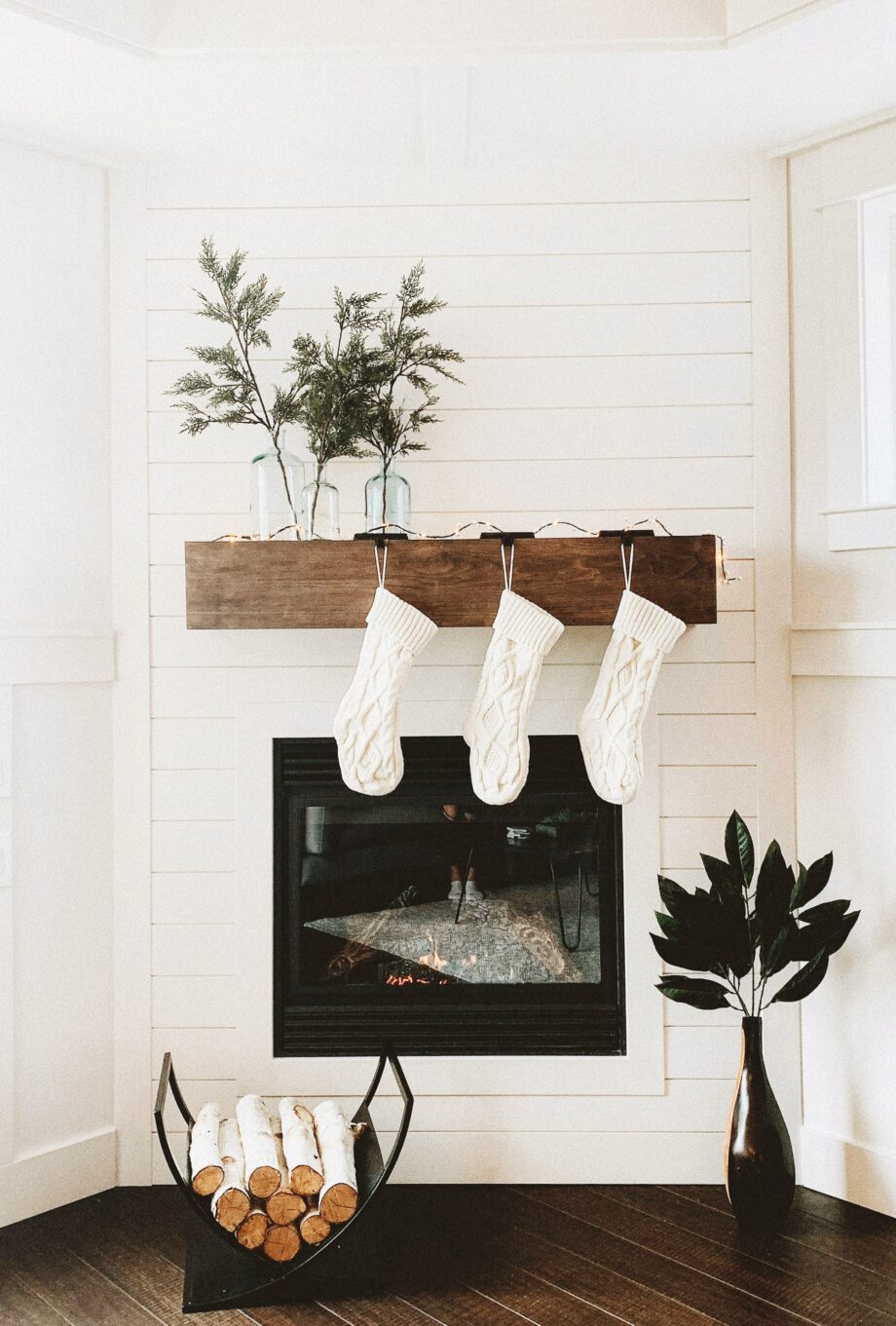 White shiplap fireplace with white stockings and greenery