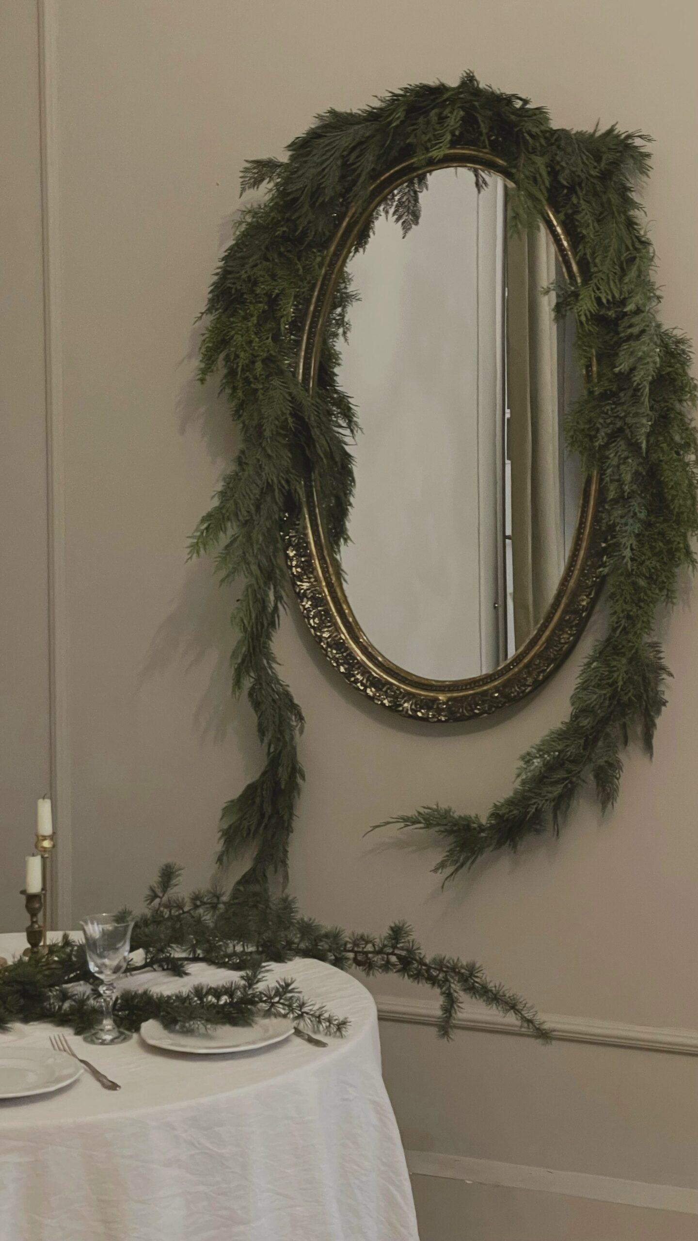 Round mirror framed with a soft green garland