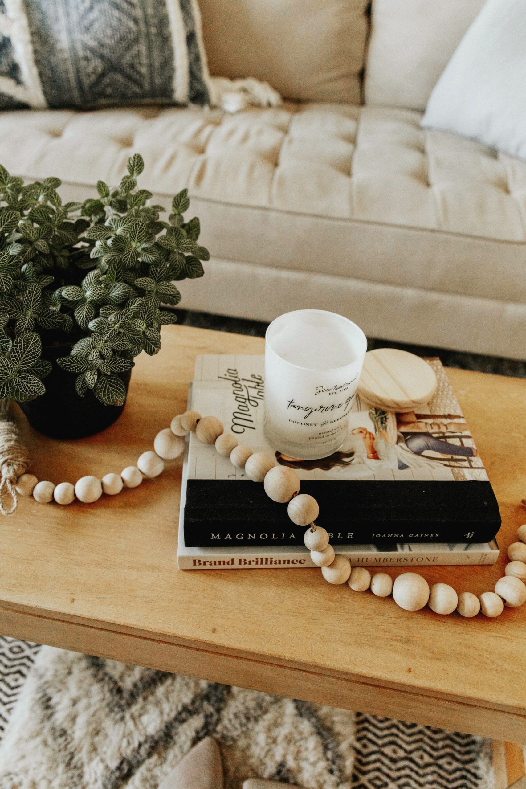 Natural wood bead garland on a coffee table with books and a candle