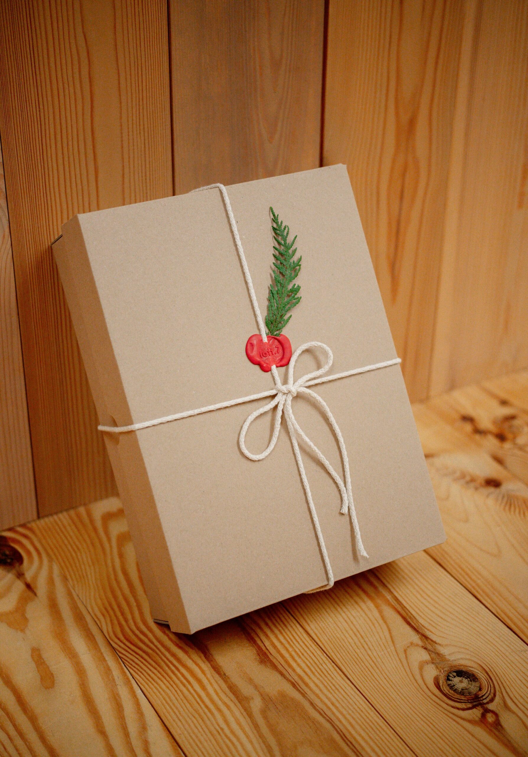Gift wrapped in kraft paper and twine with a sprig of greenery