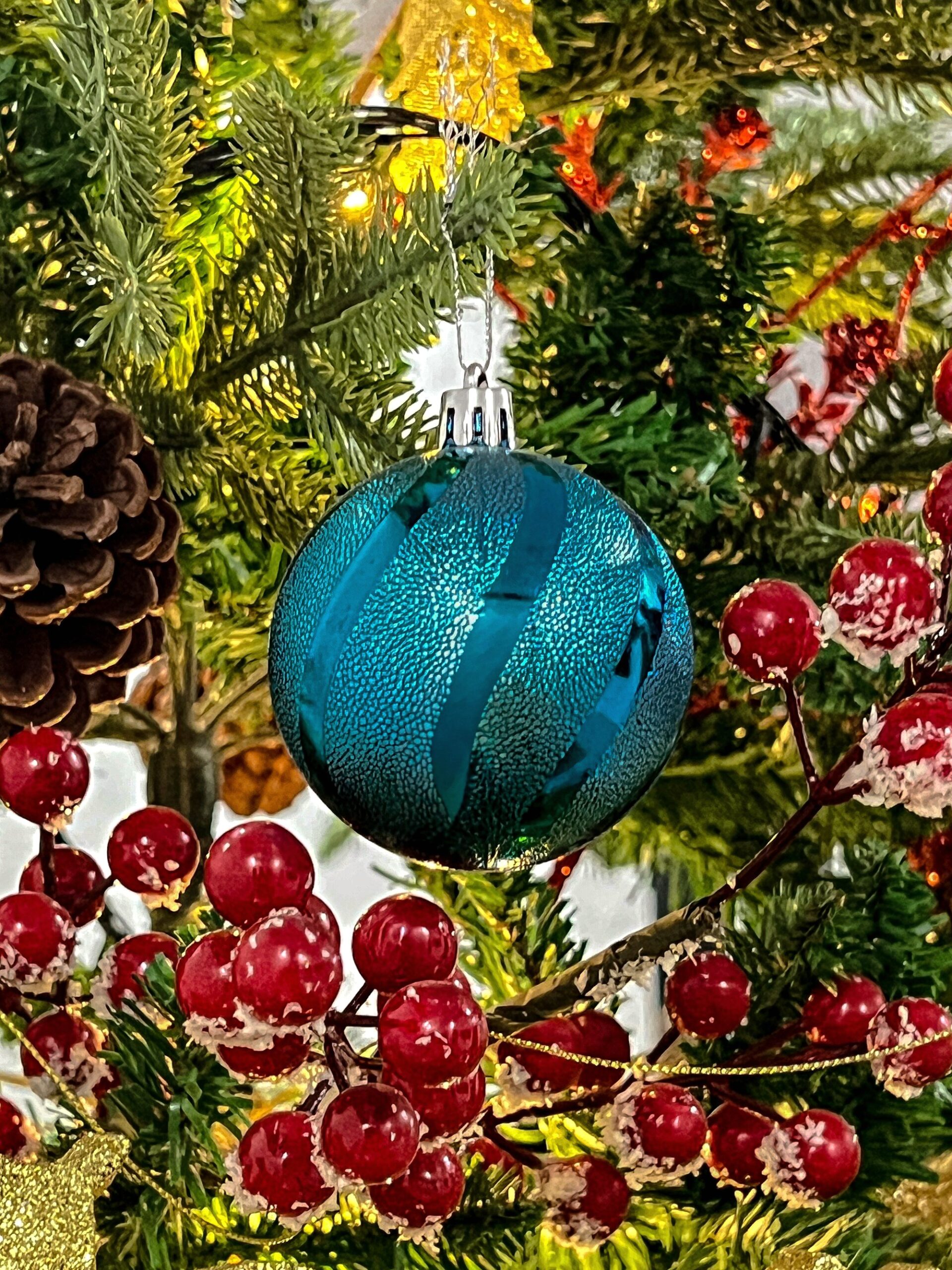 Sea-glass teal ornament hanging on a Christmas tree