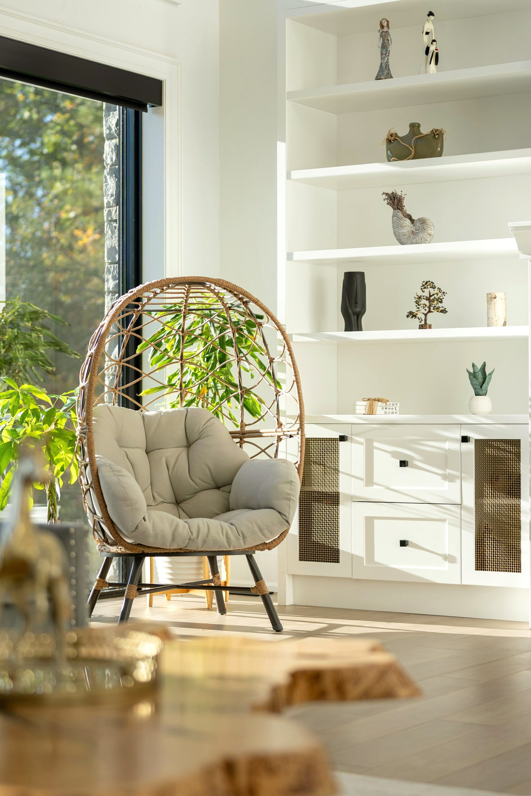 Rattan hanging chair beside white shelves
