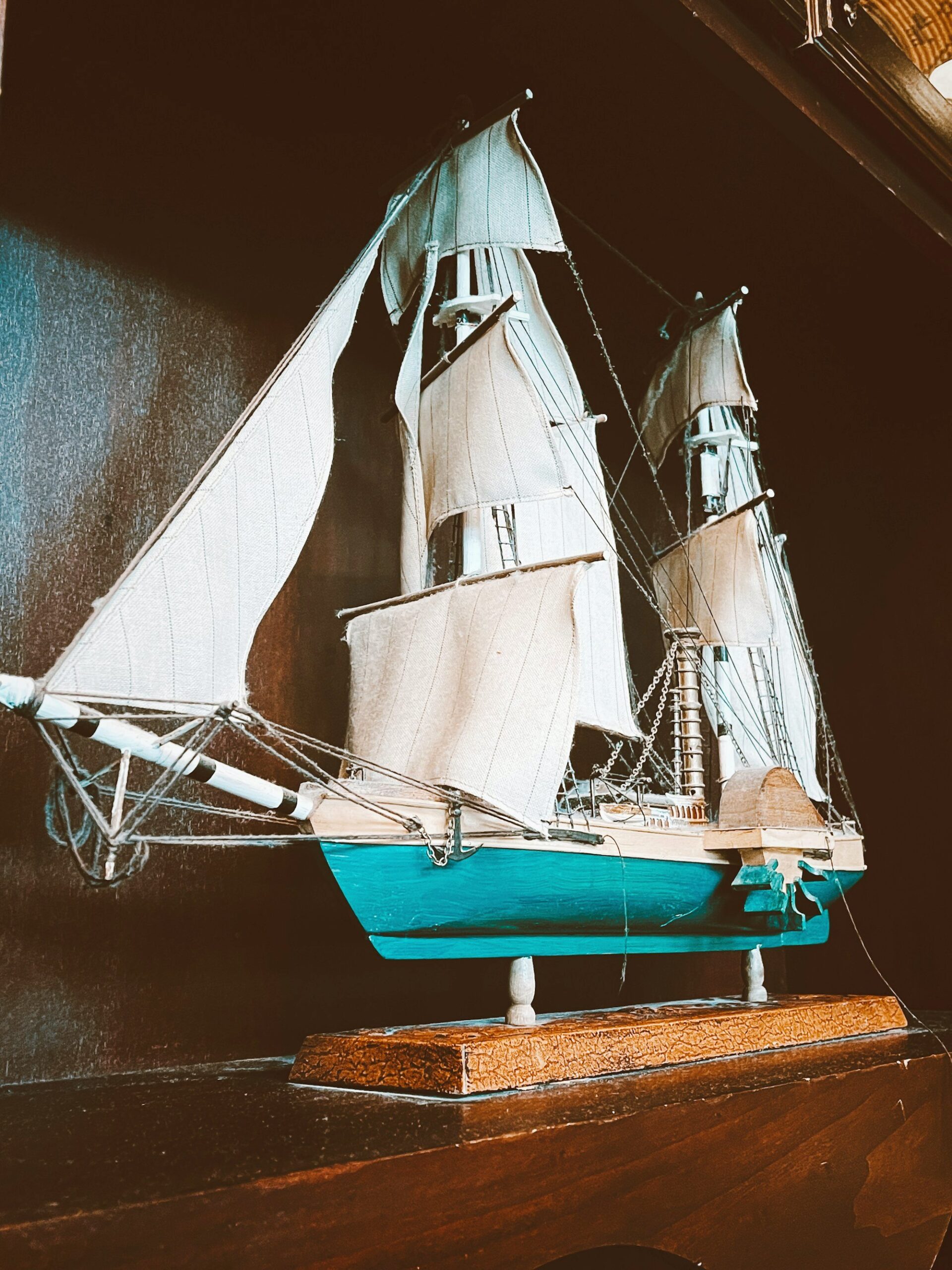 Painted wooden sailboat model in blue and white