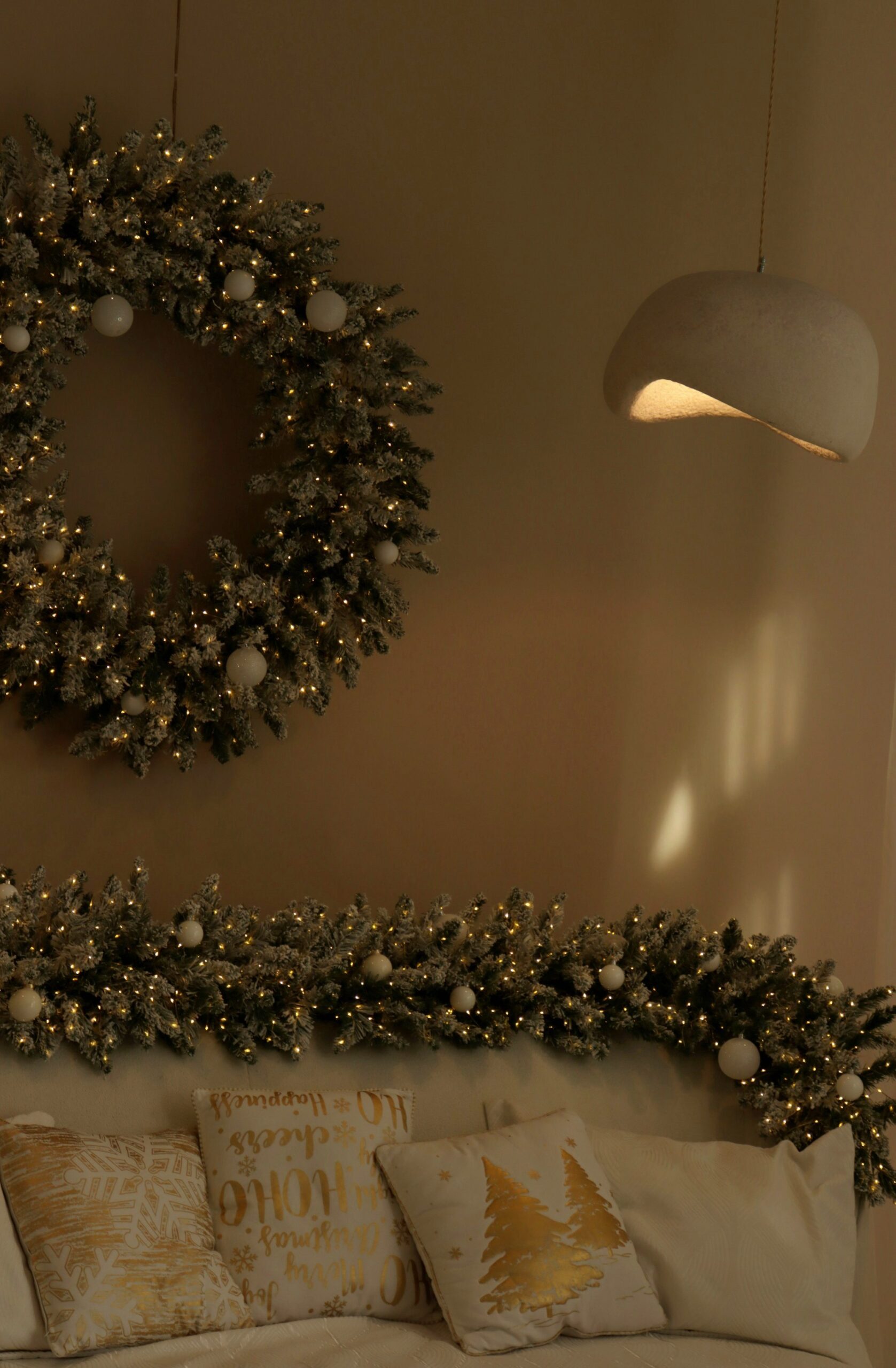 Christmas wreath and garland above festive pillows