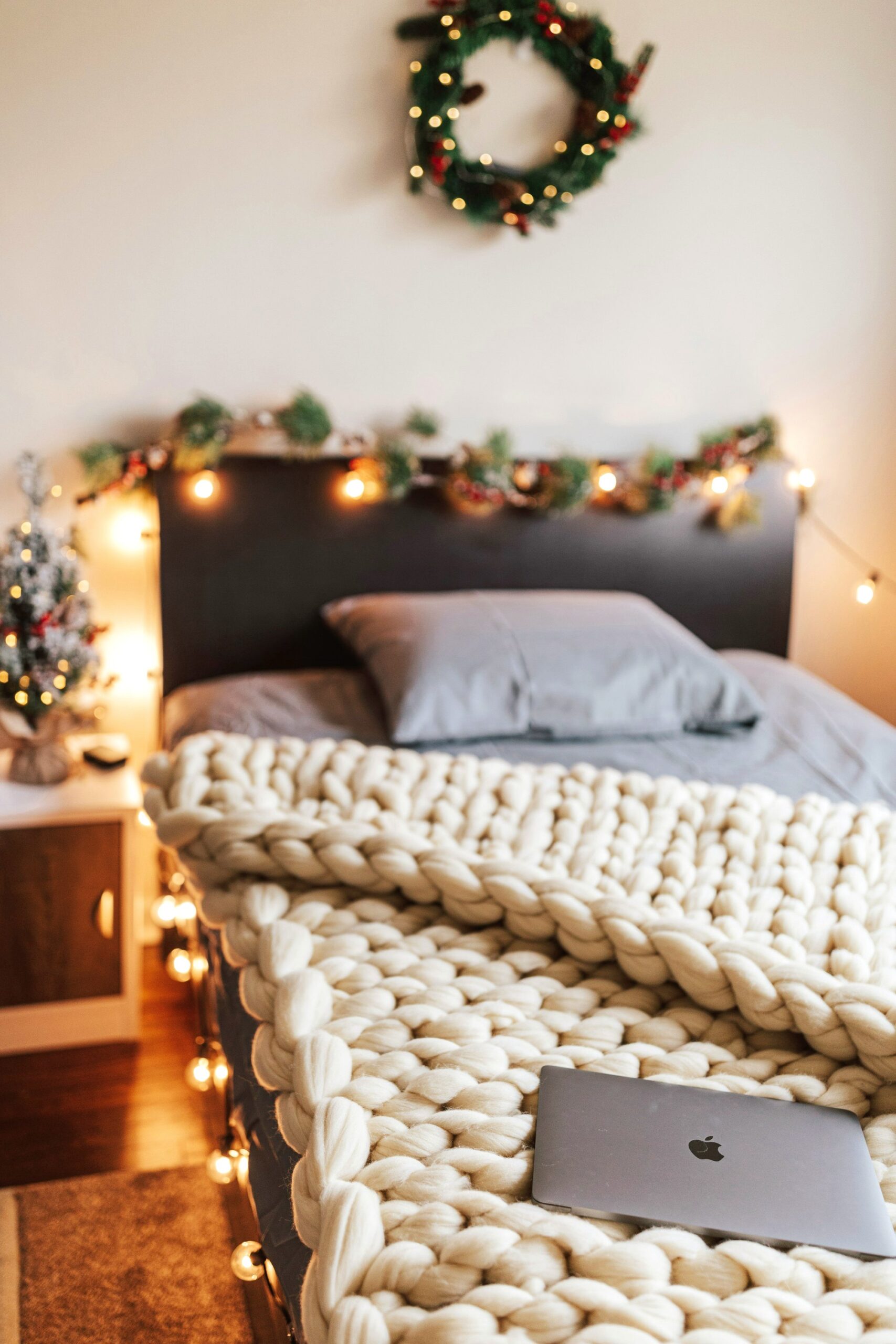 Garland and lights along a headboard with a knit blanket
