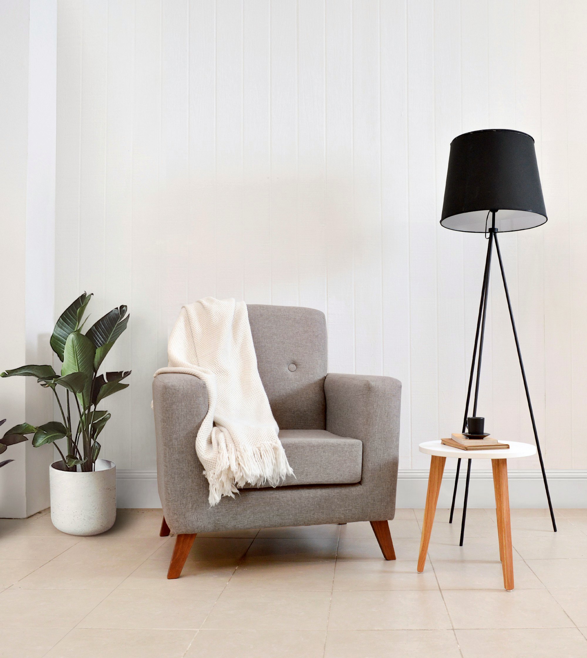 Reading nook with an armchair, throw blanket and floor lamp