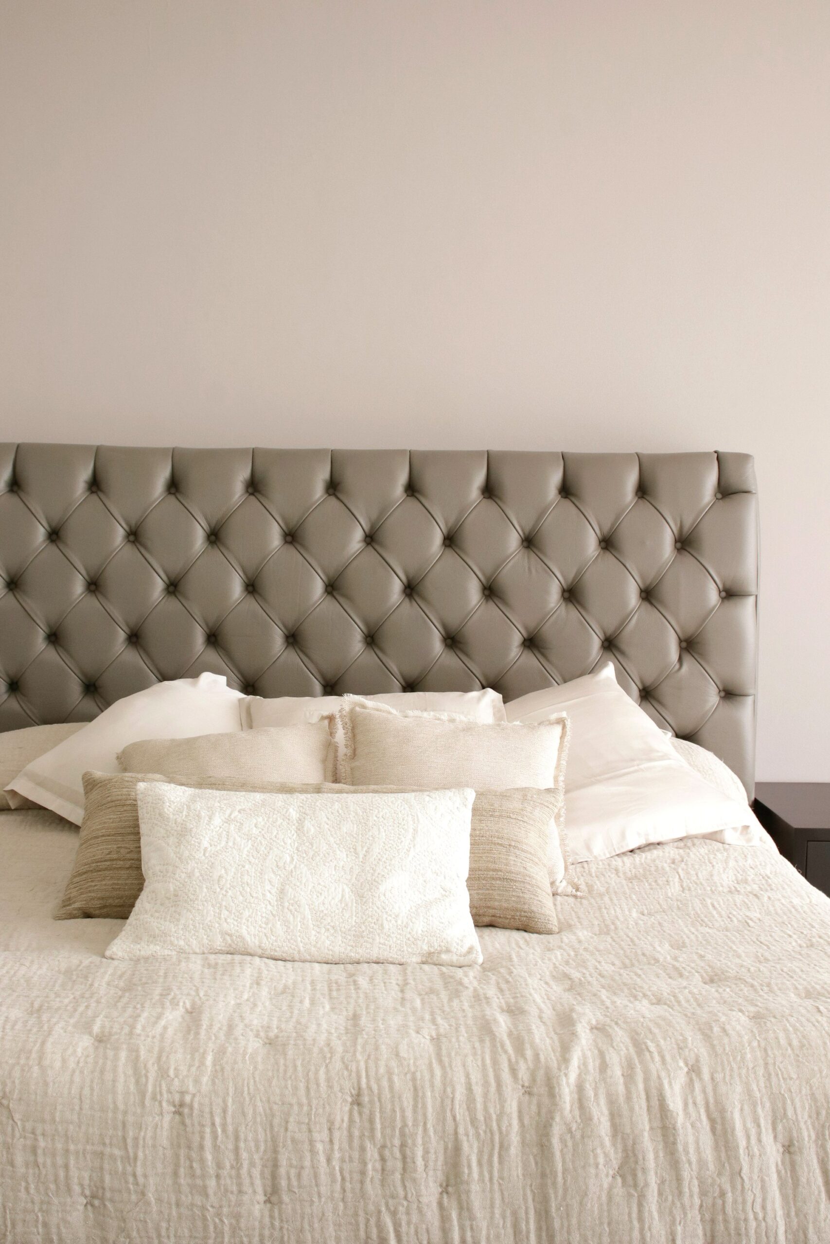 Tufted headboard with textured neutral throw pillows